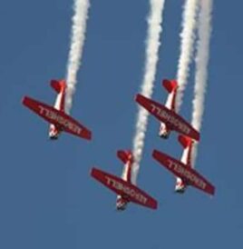 flying aerobatic planes against bright blue sky