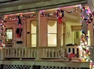 Front porch of Franklin Street Inn decorated with lights at Christmas