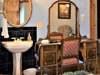 Bathroom in Rhodes Room with antique dresser and pedestal sink