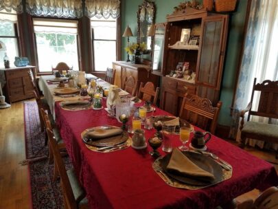 dining room table set for breakfast with red tablecloth