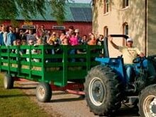 people riding in wagon pulled by tractor